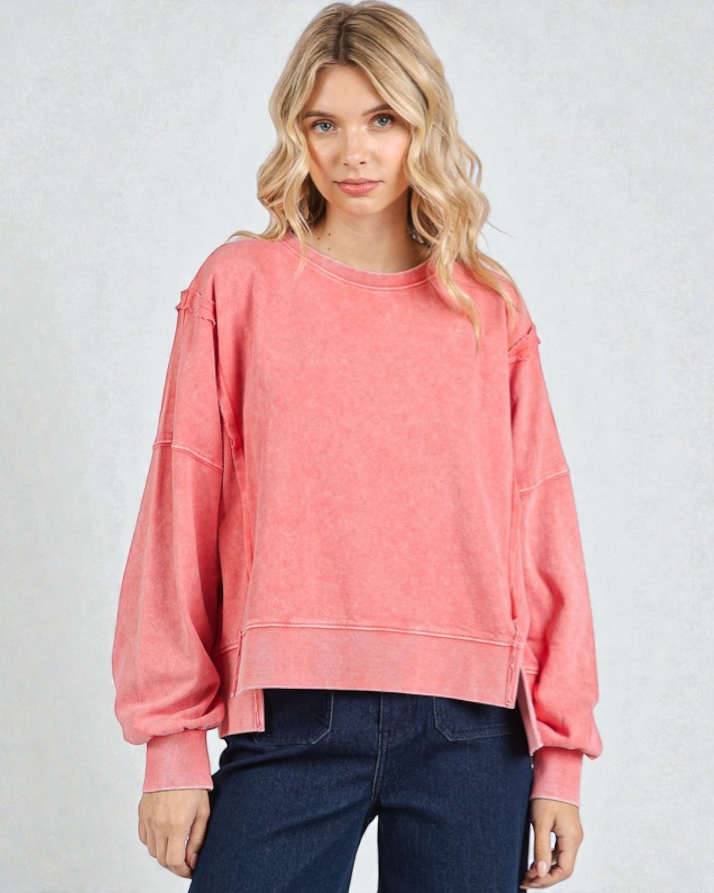 Woman wearing a pink sweatshirt against a plain background