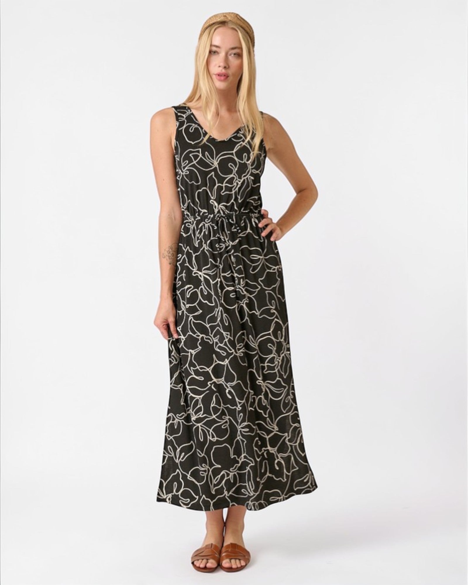 Woman wearing a black floral patterned dress on a white background