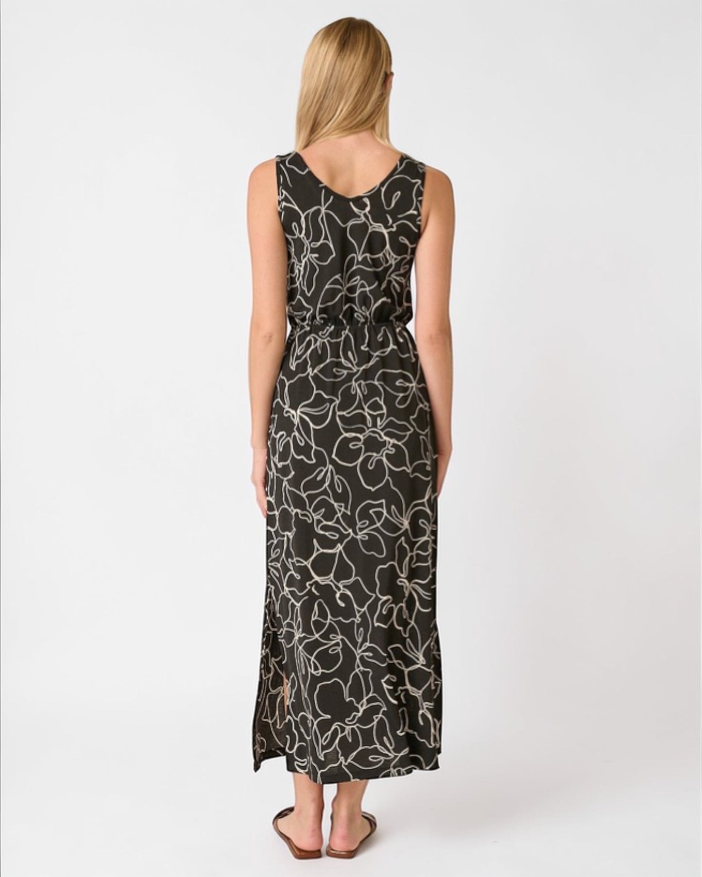 Woman wearing a black floral patterned dress on a white background