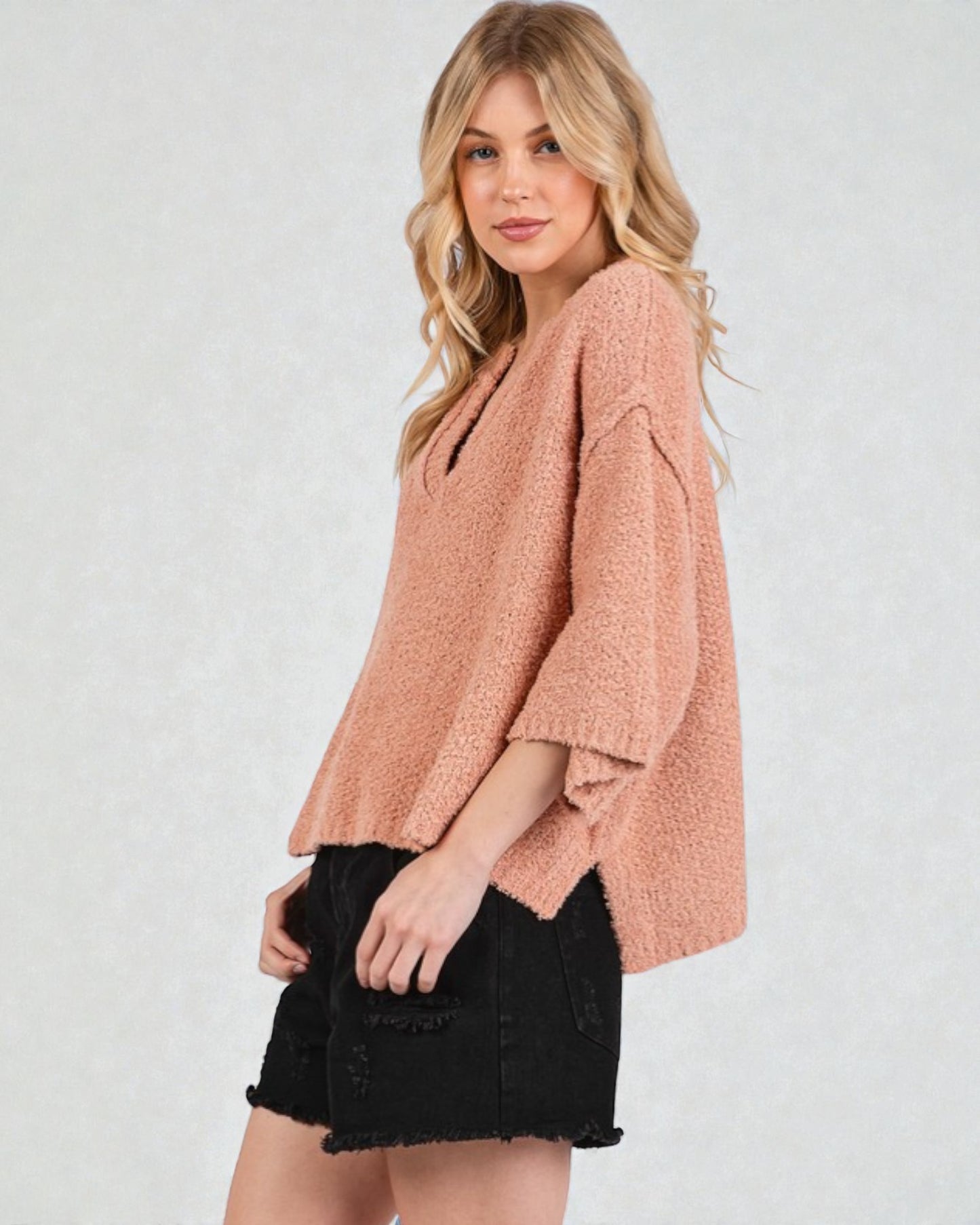 Woman wearing a pink sweater and black skirt on a white background