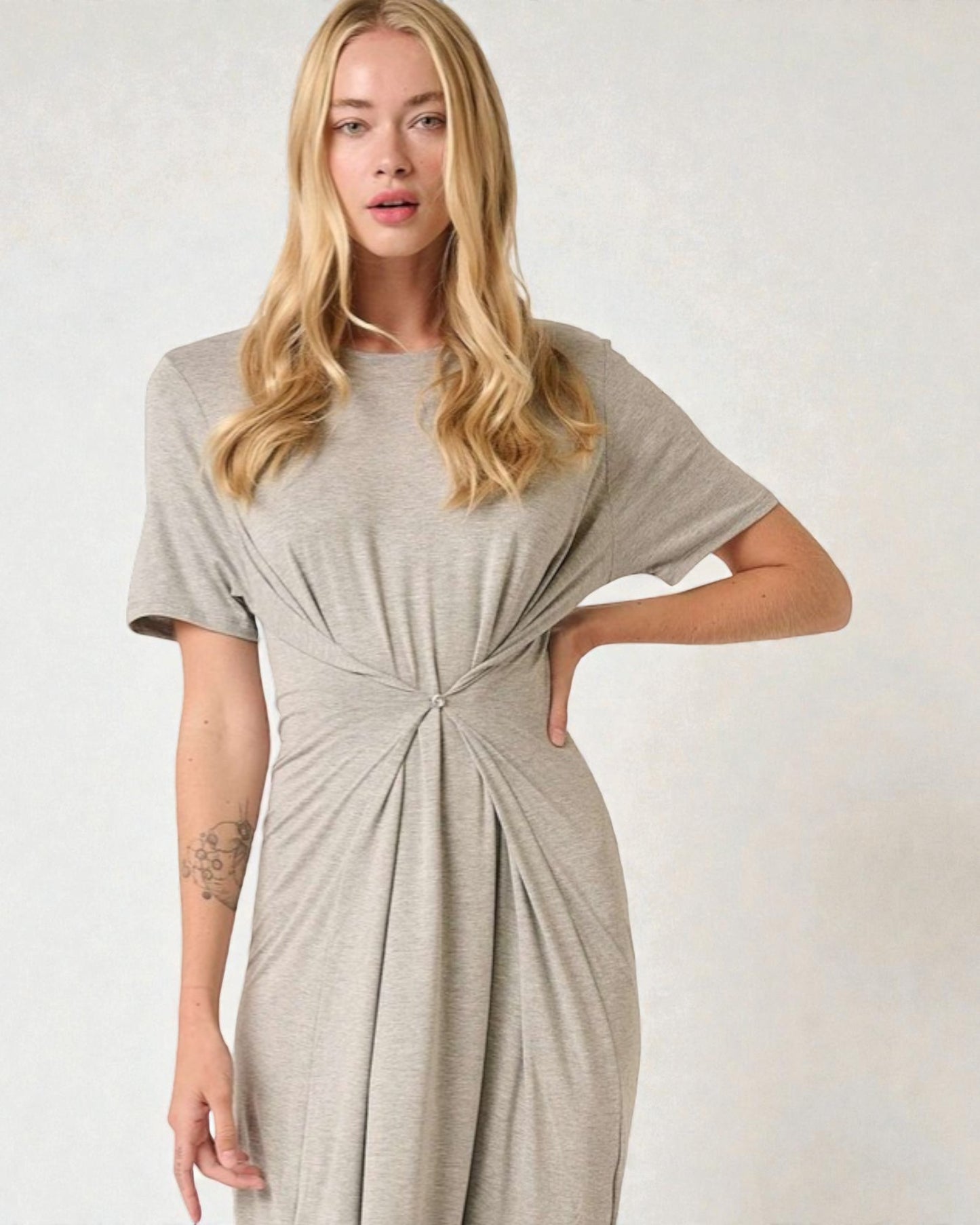 Woman wearing a gray dress with a knot detail on a white background