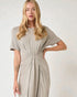 Woman wearing a gray dress with a knot detail on a white background
