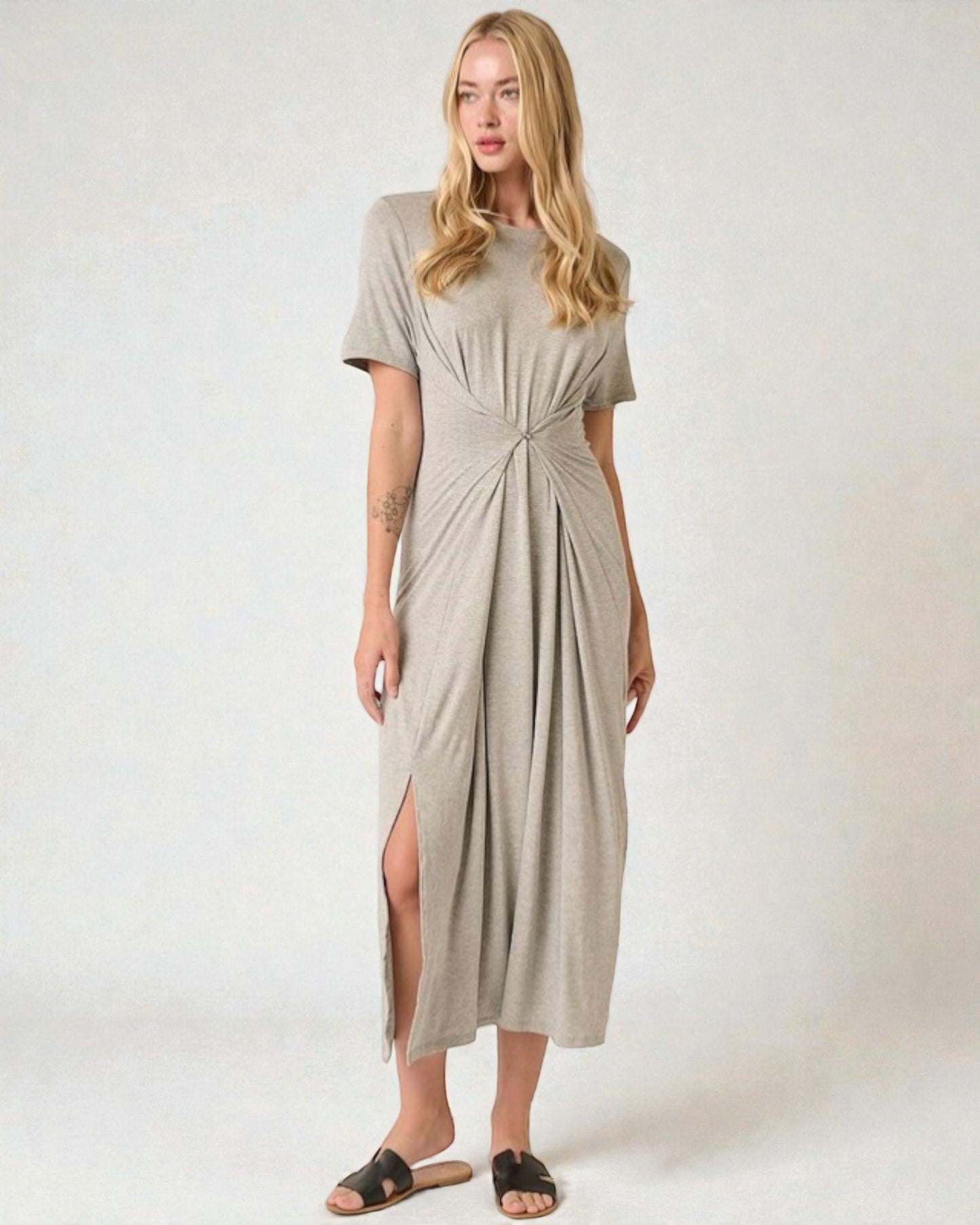 Woman wearing a beige dress with a knot detail on a white background