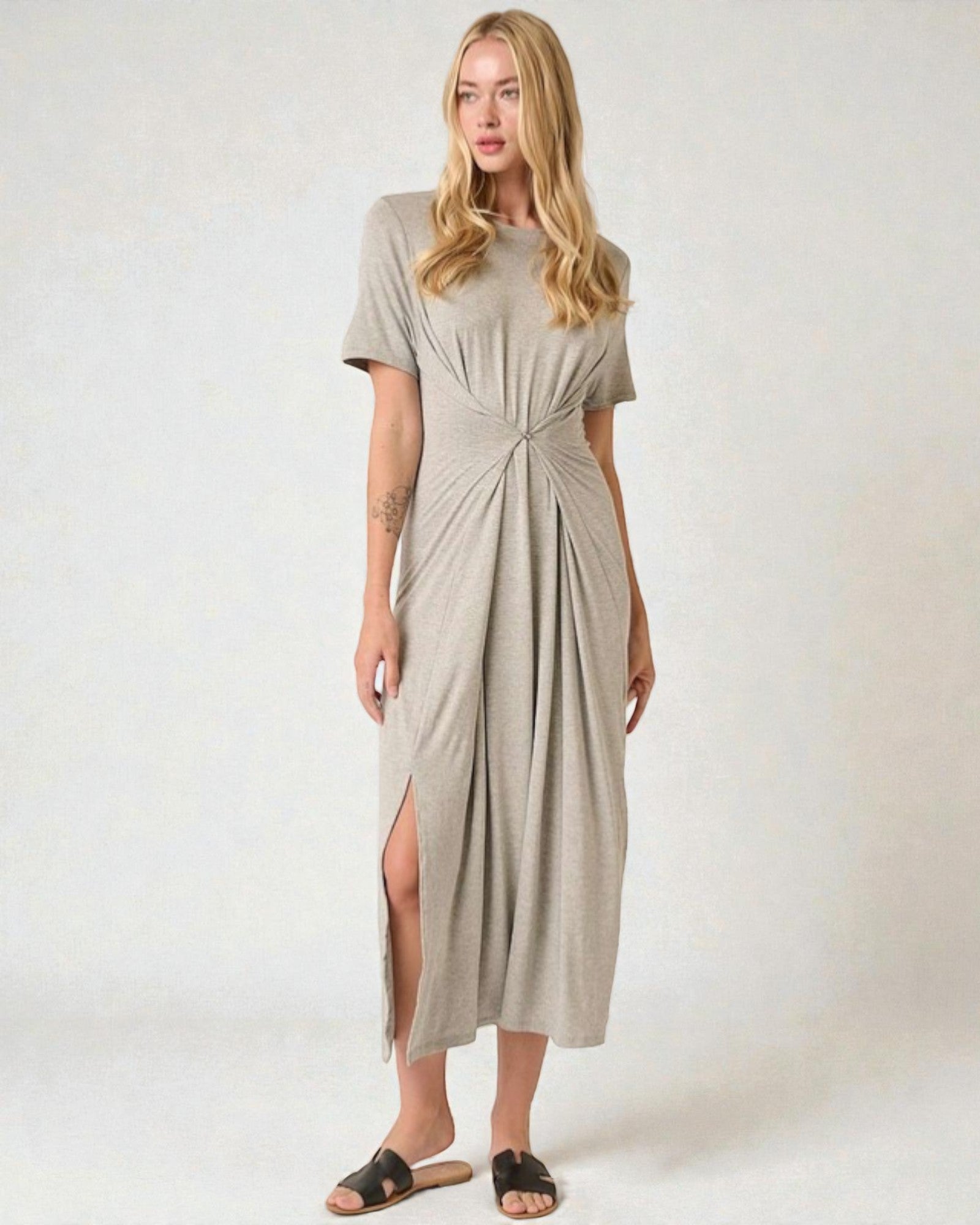 Woman wearing a beige dress with a knot detail on a white background