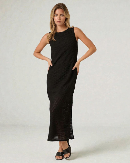 Woman wearing a black sleeveless dress against a white background