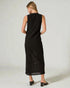 Woman wearing a black sleeveless dress against a white background
