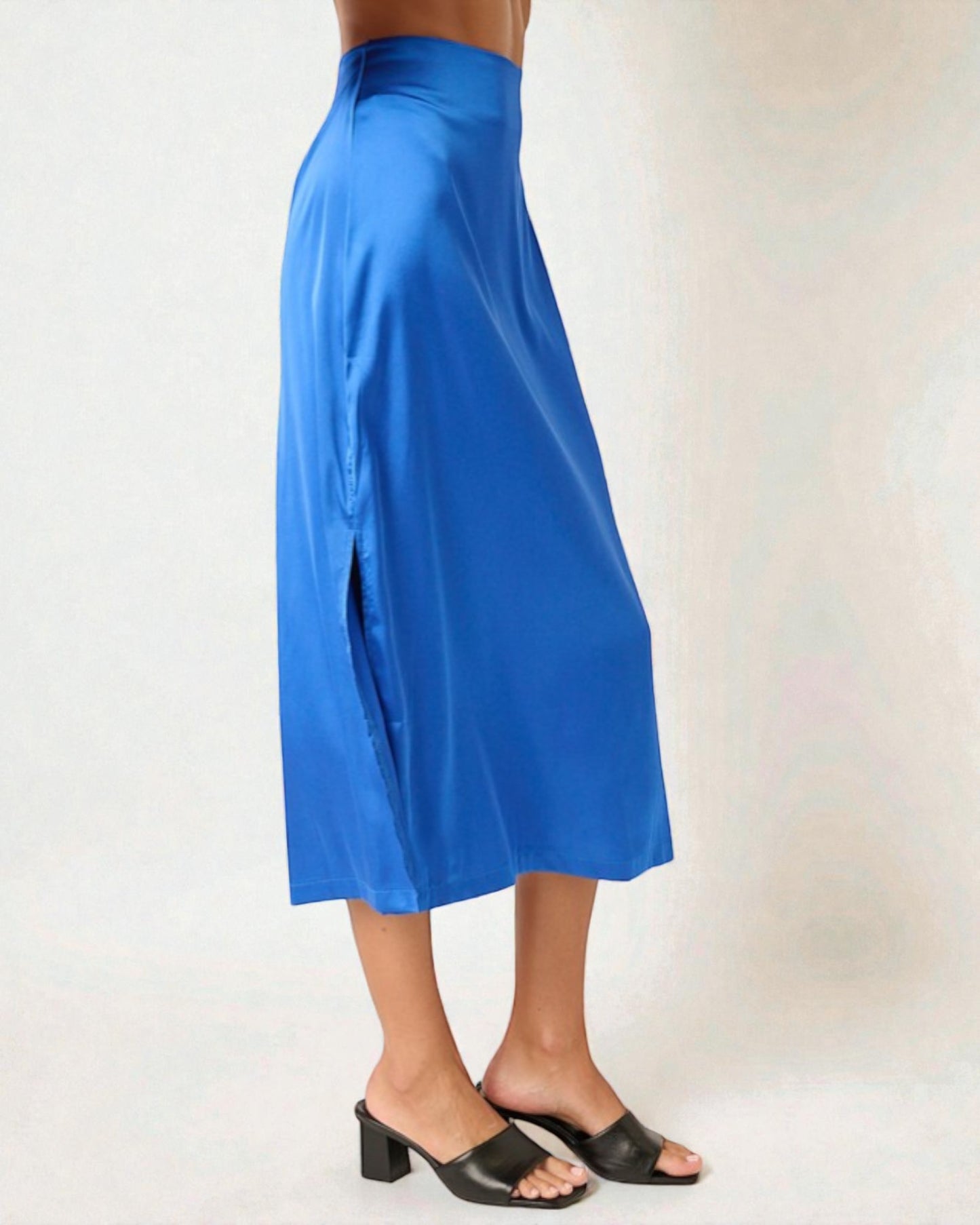 Blue skirt worn by a person on a plain background