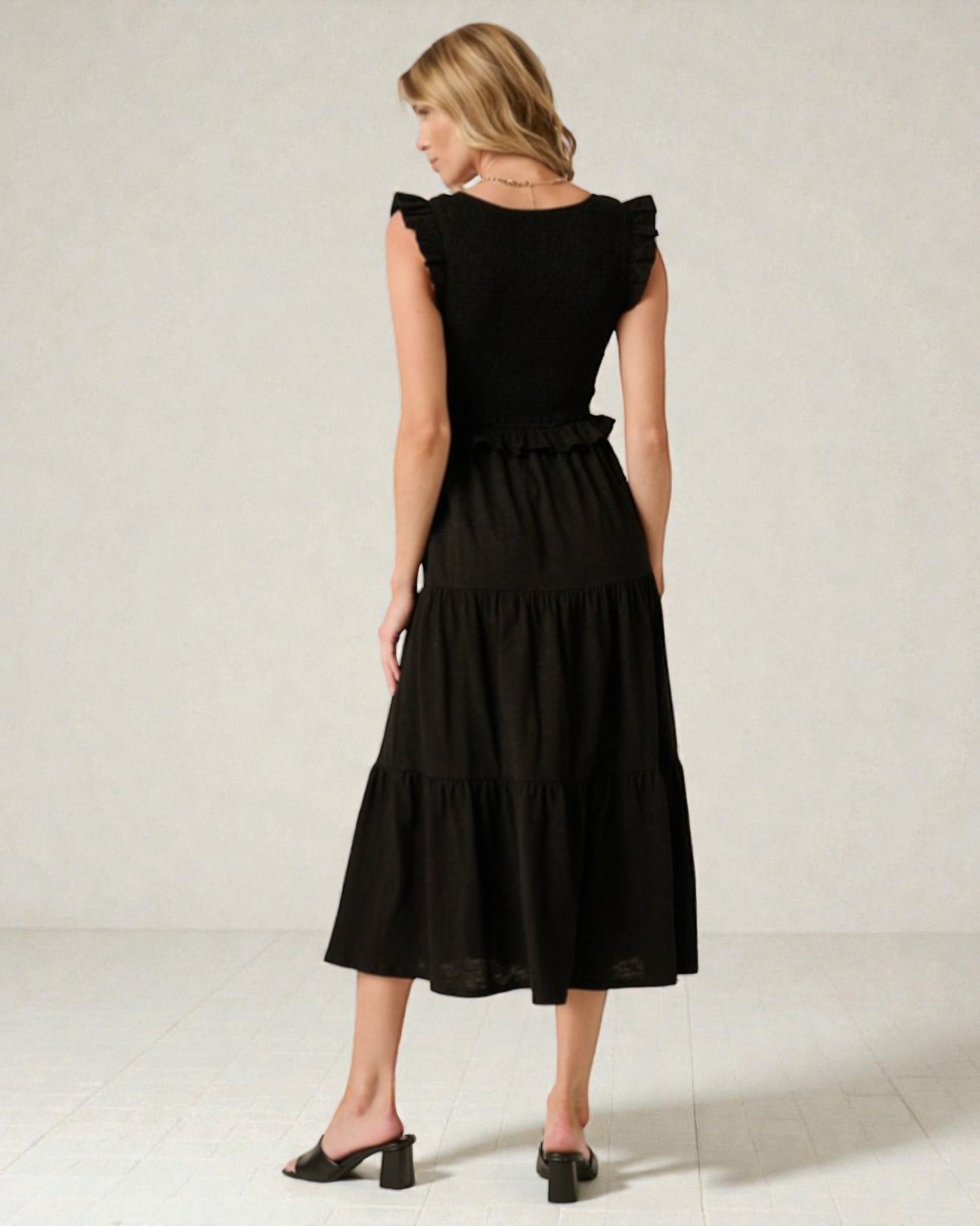 Woman wearing a black dress against a plain background