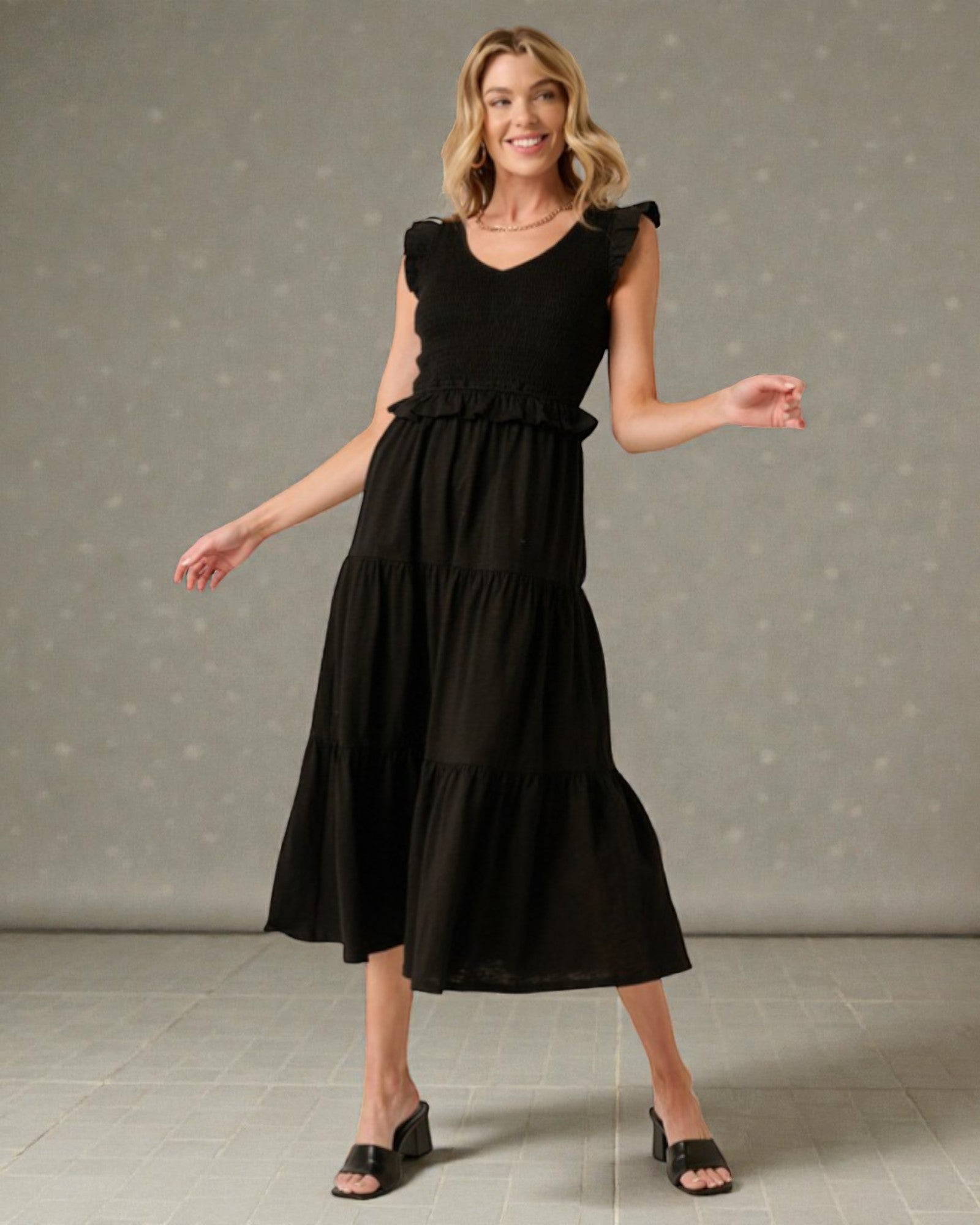 Woman wearing a black dress against a gray background