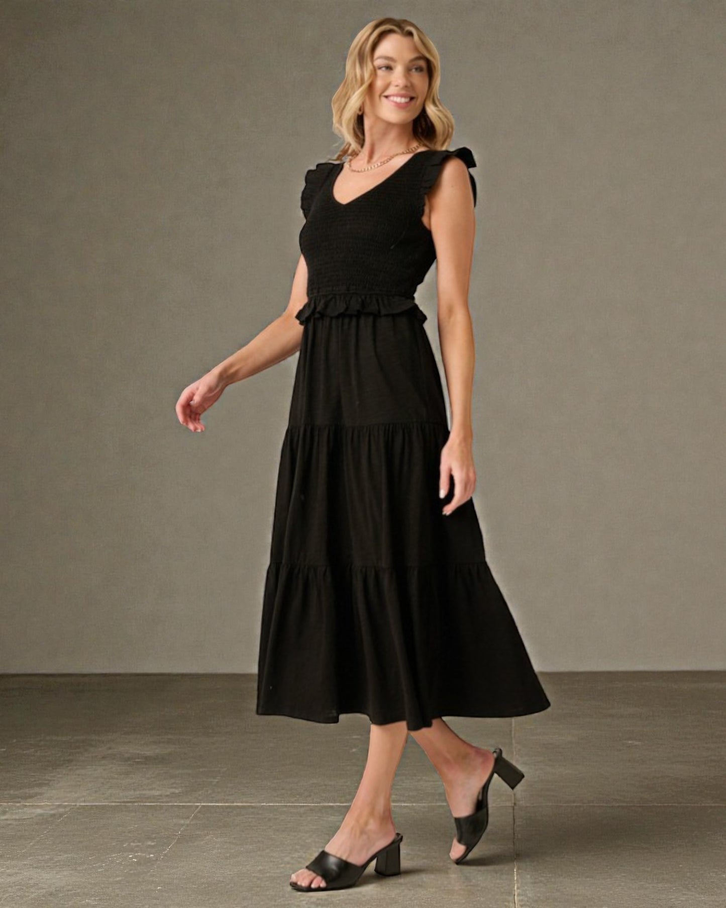 Woman wearing a black dress against a neutral background