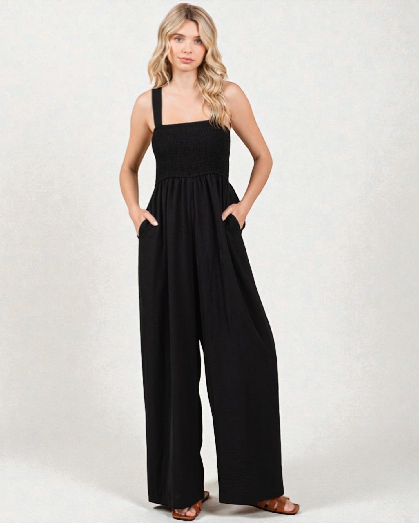 Woman wearing a black jumpsuit on a white background