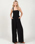 Woman wearing a black jumpsuit on a white background