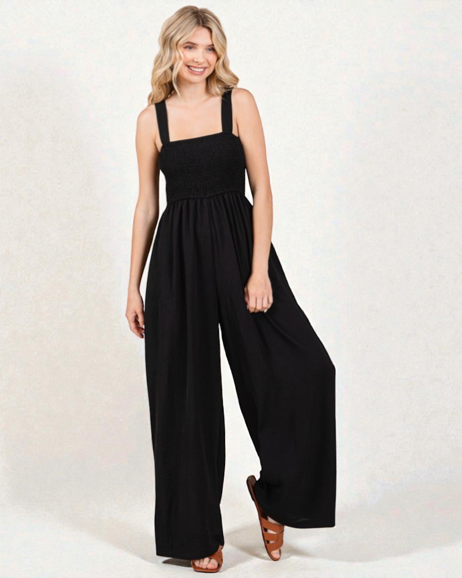 Woman wearing a black jumpsuit on a white background