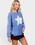 Woman wearing a blue sweatshirt with a white graphic on a plain background