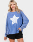 Woman wearing a blue sweatshirt with a white graphic design on a plain background