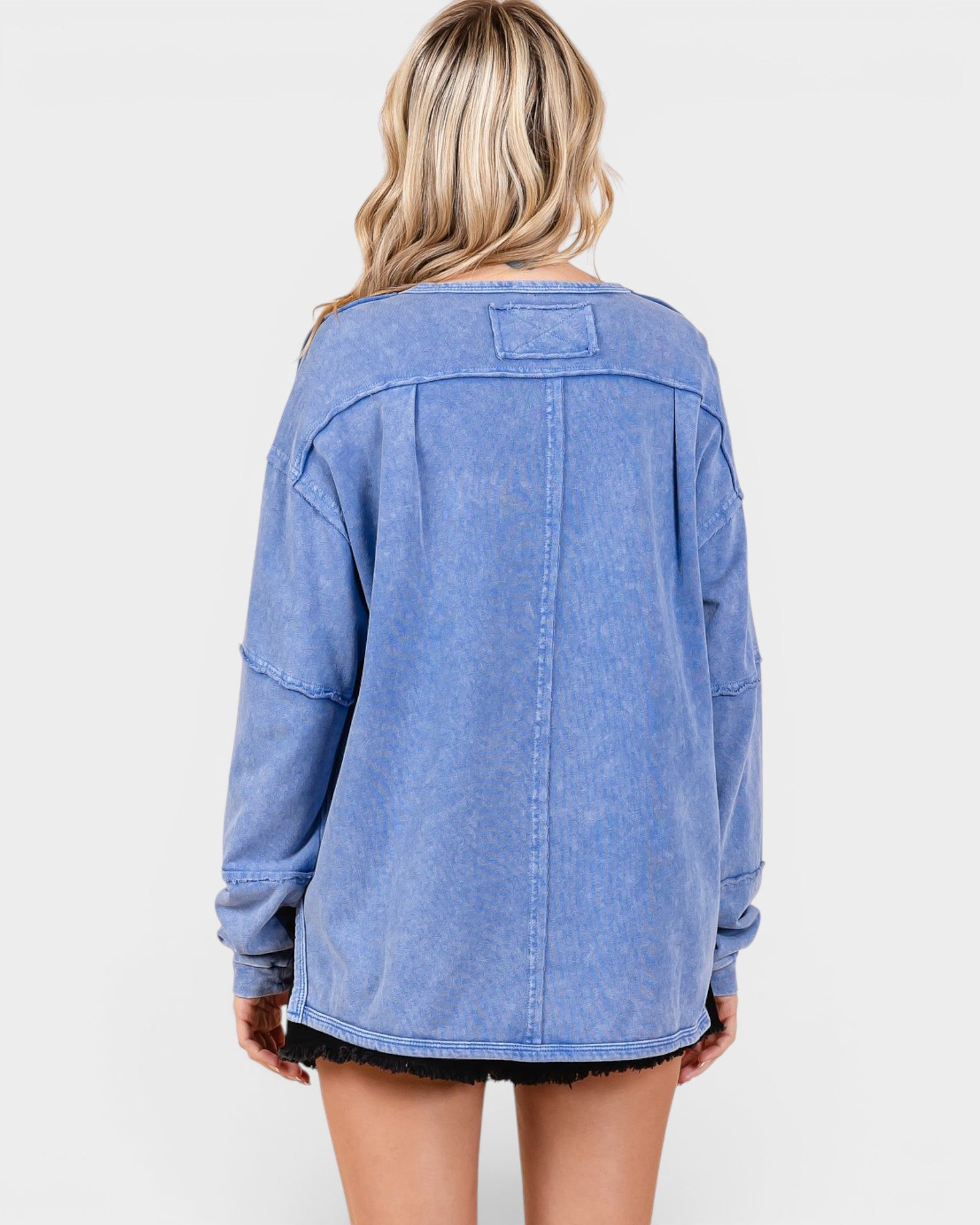 Blue denim jacket worn by a person on a white background