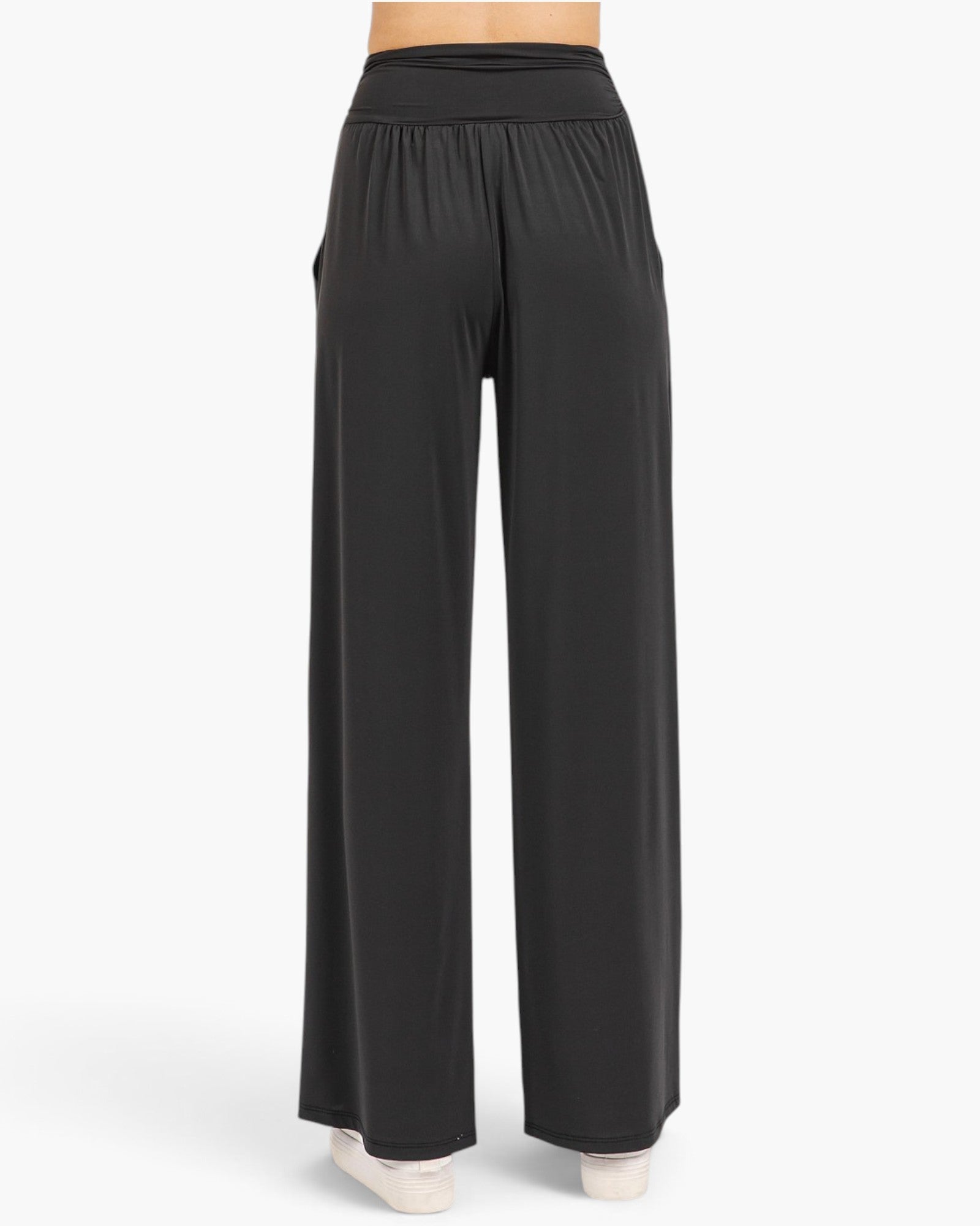 Black wide-leg lounge pants shown from the back on a model, featuring an elastic waistband and side pockets, against a plain white studio background.