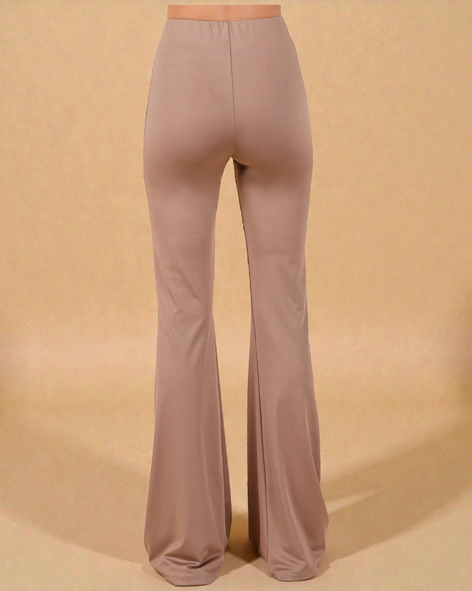 Pair of beige flared pants on a beige background