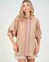 Woman wearing a striped shirt and shorts on a light background