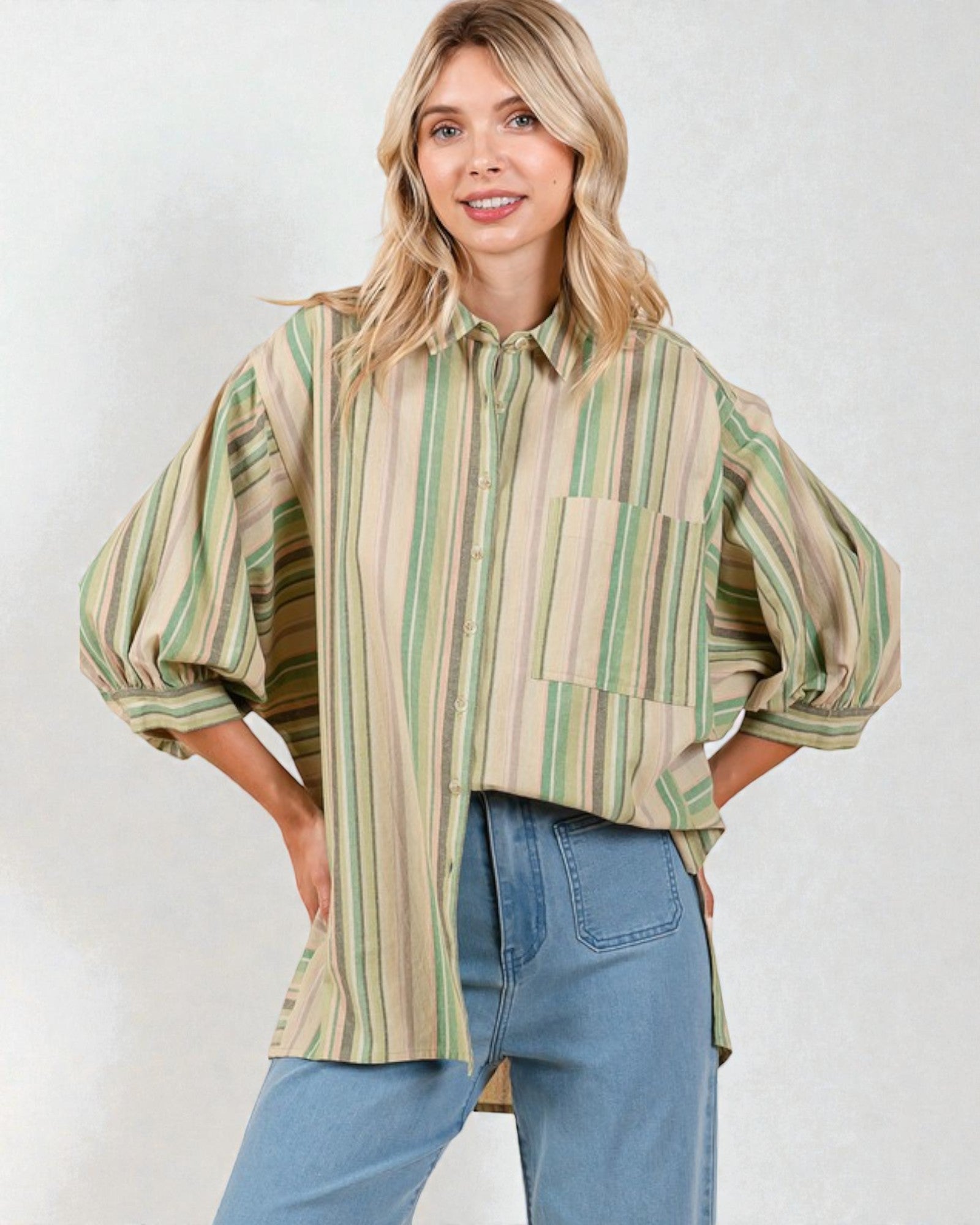 Woman wearing a striped shirt and jeans against a white background
