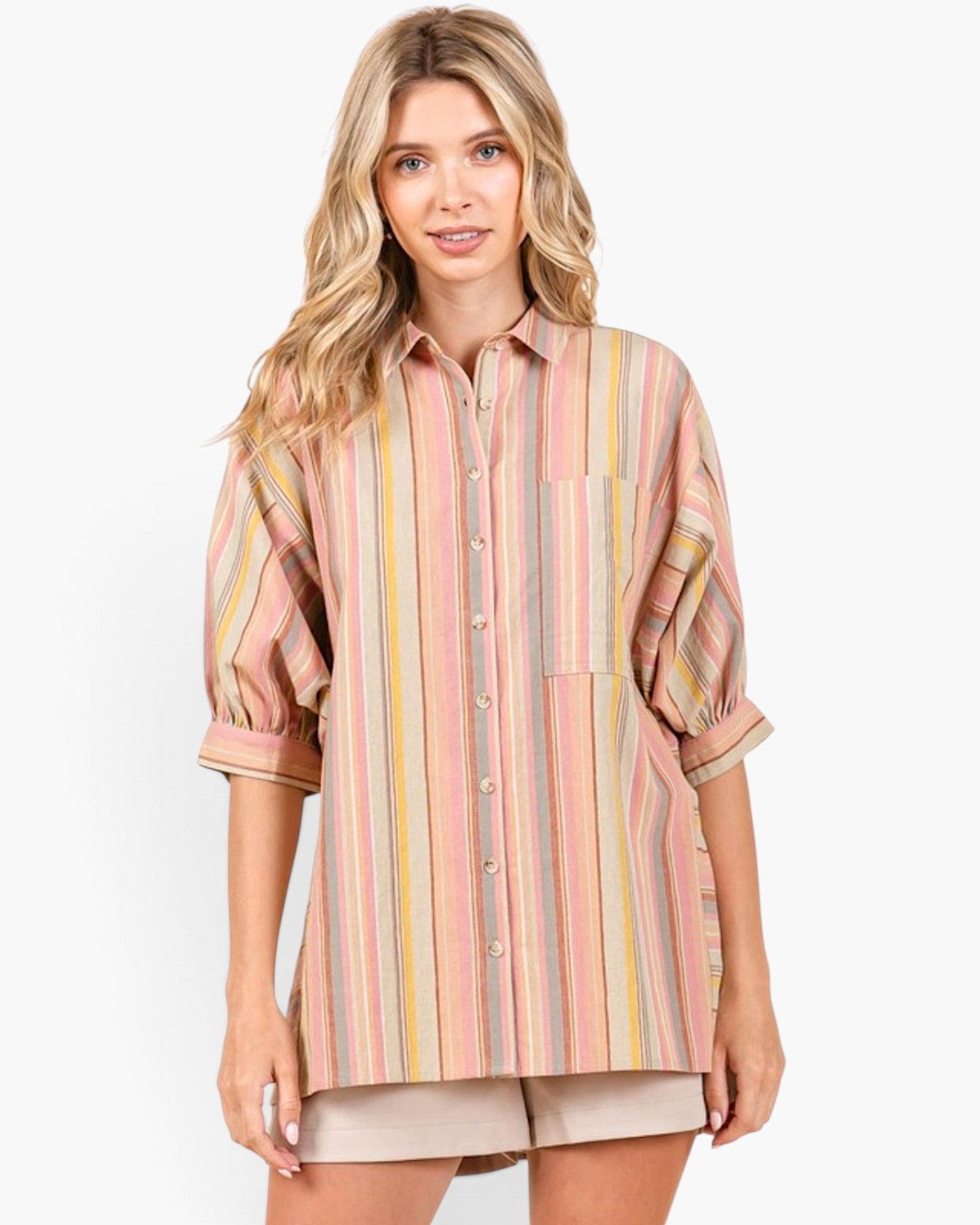 A woman modeling a pastel striped button-up shirt with puff sleeves and beige shorts against a plain white studio background.