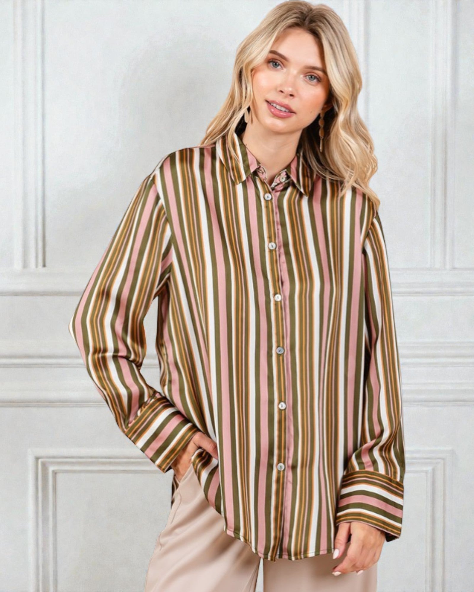 Woman wearing a striped shirt against a white paneled wall