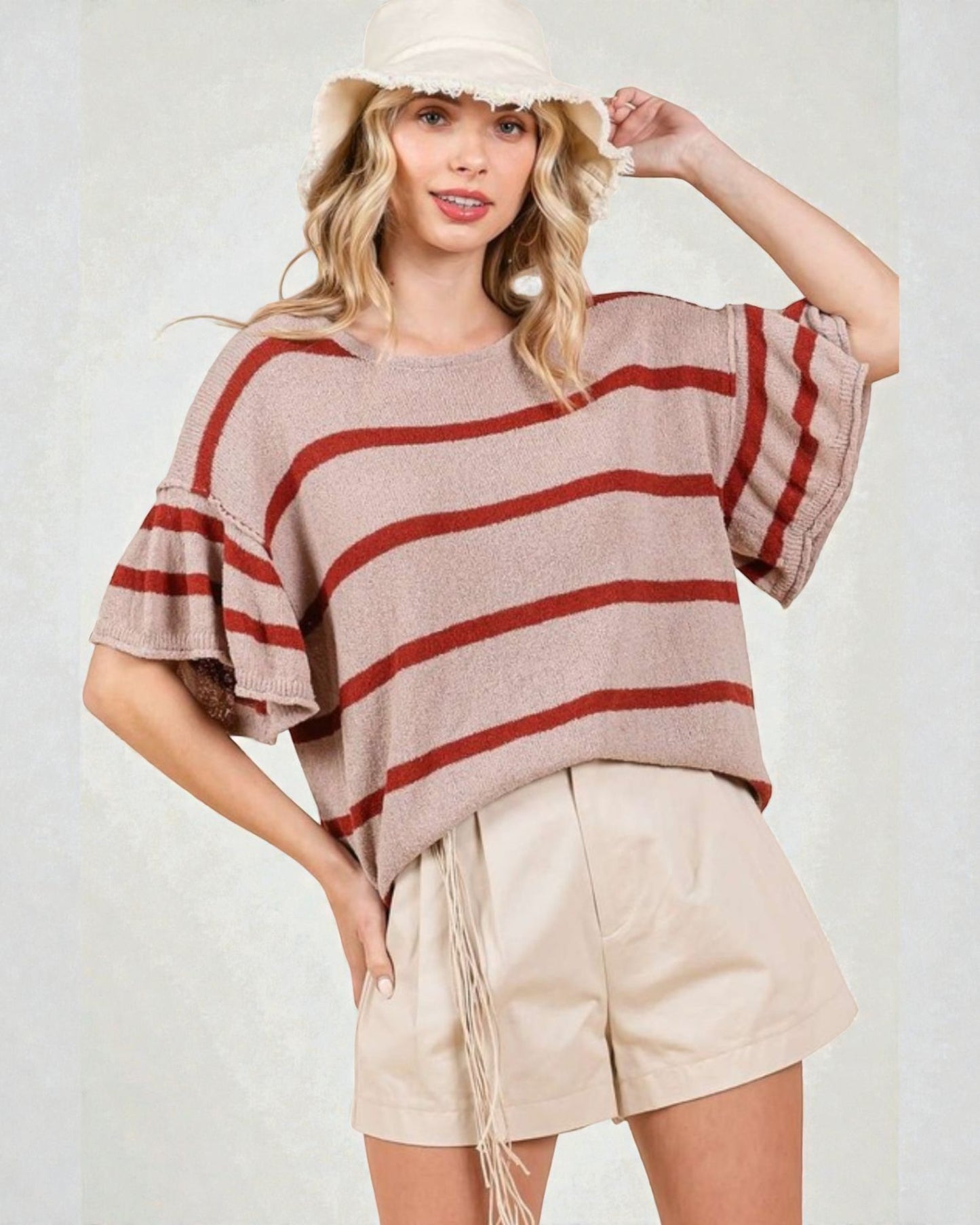 Woman wearing a striped sweater and shorts with a white background