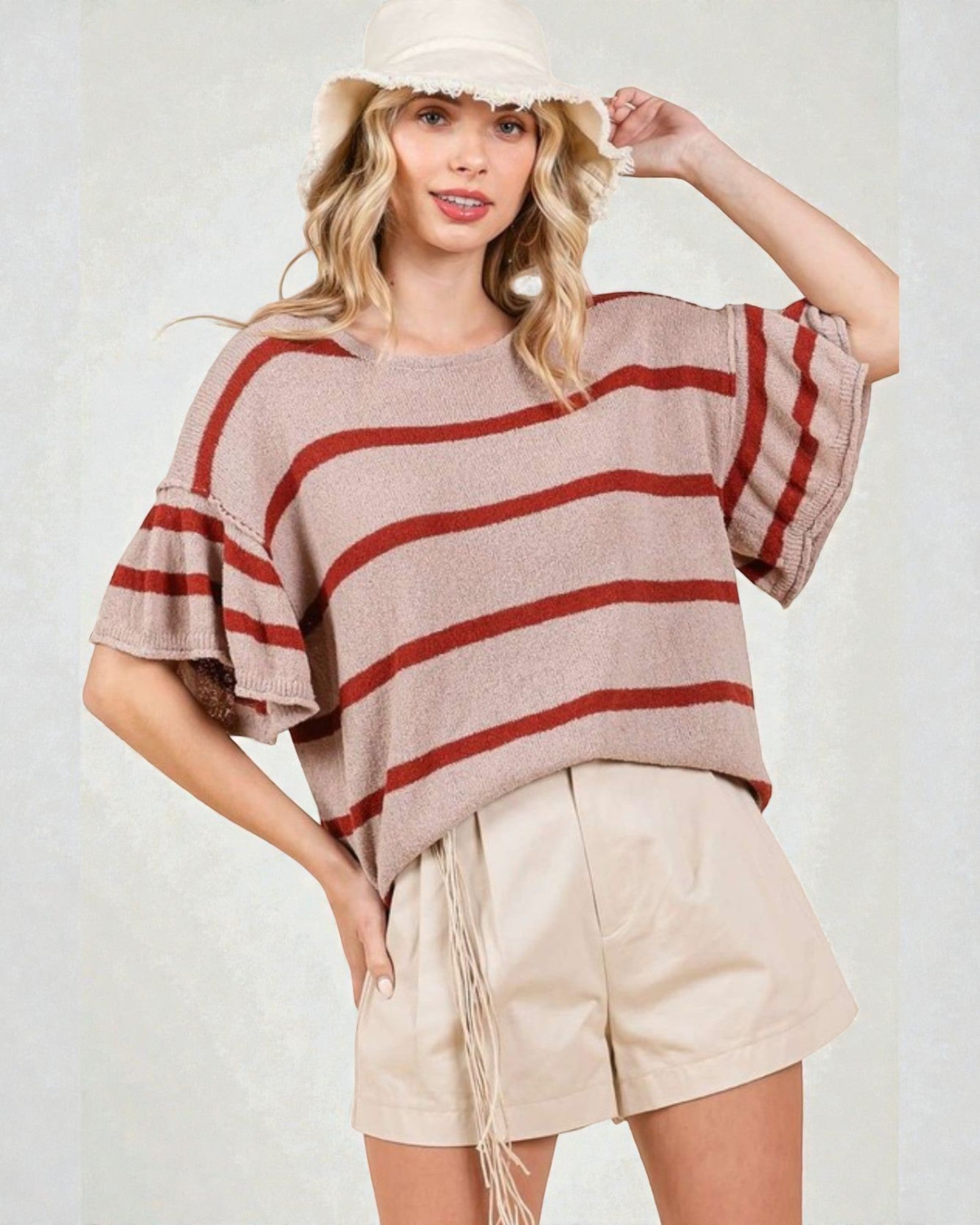 Woman wearing a striped sweater and shorts with a white background