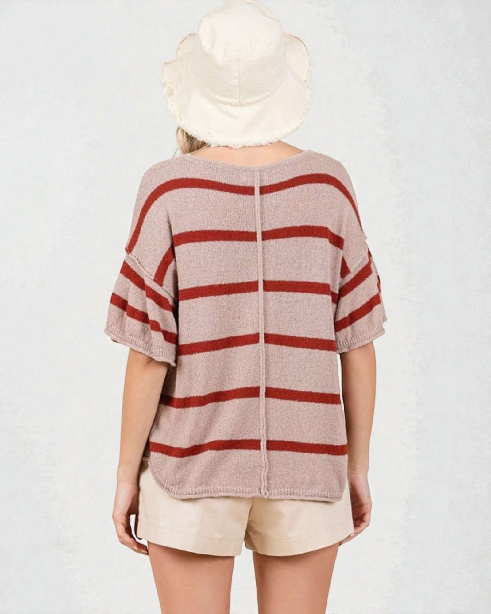 Person wearing a striped shirt and hat on a plain background