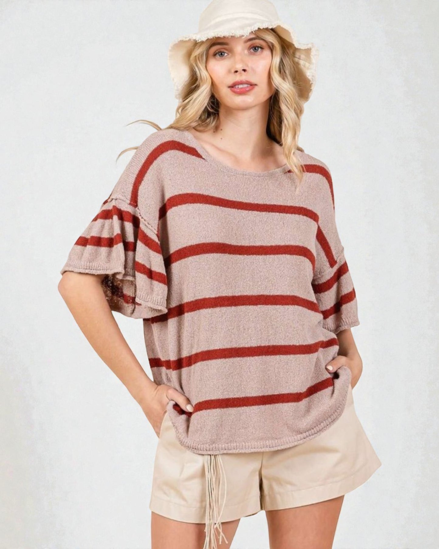 Woman wearing a striped sweater and shorts on a white background