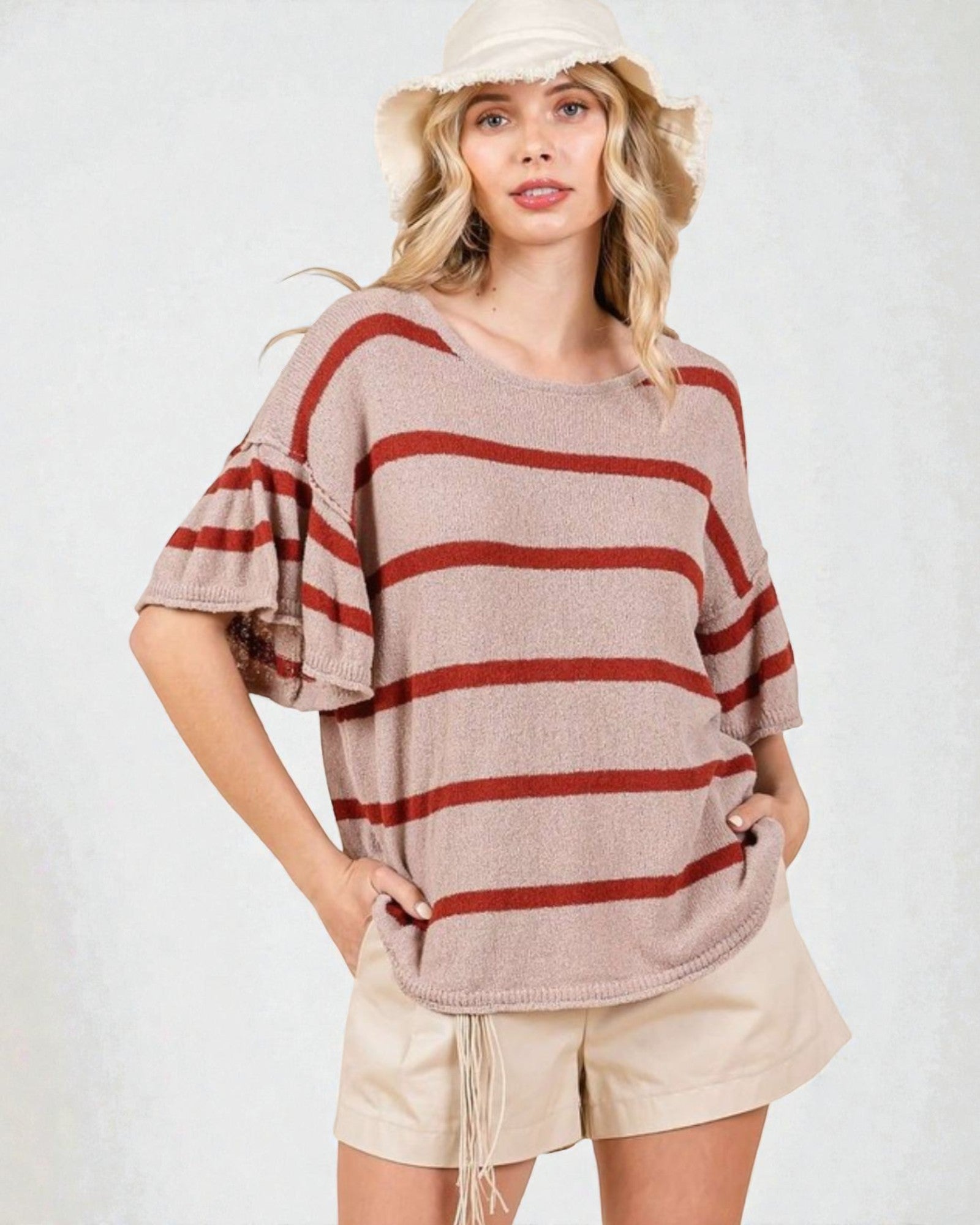 Woman wearing a striped sweater and shorts on a white background