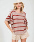 Woman wearing a striped sweater and shorts on a white background