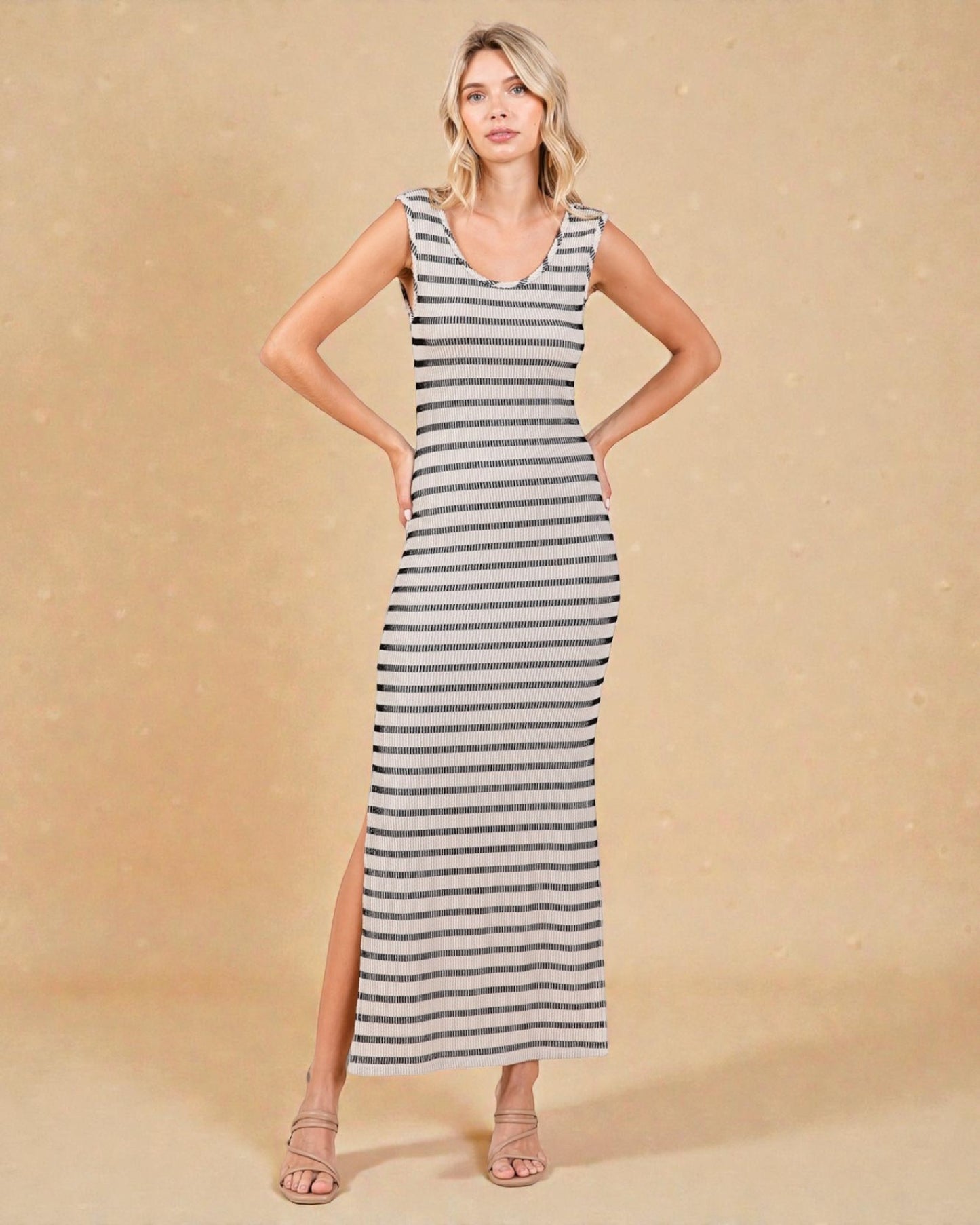 Woman wearing a striped dress with a side slit on a beige background