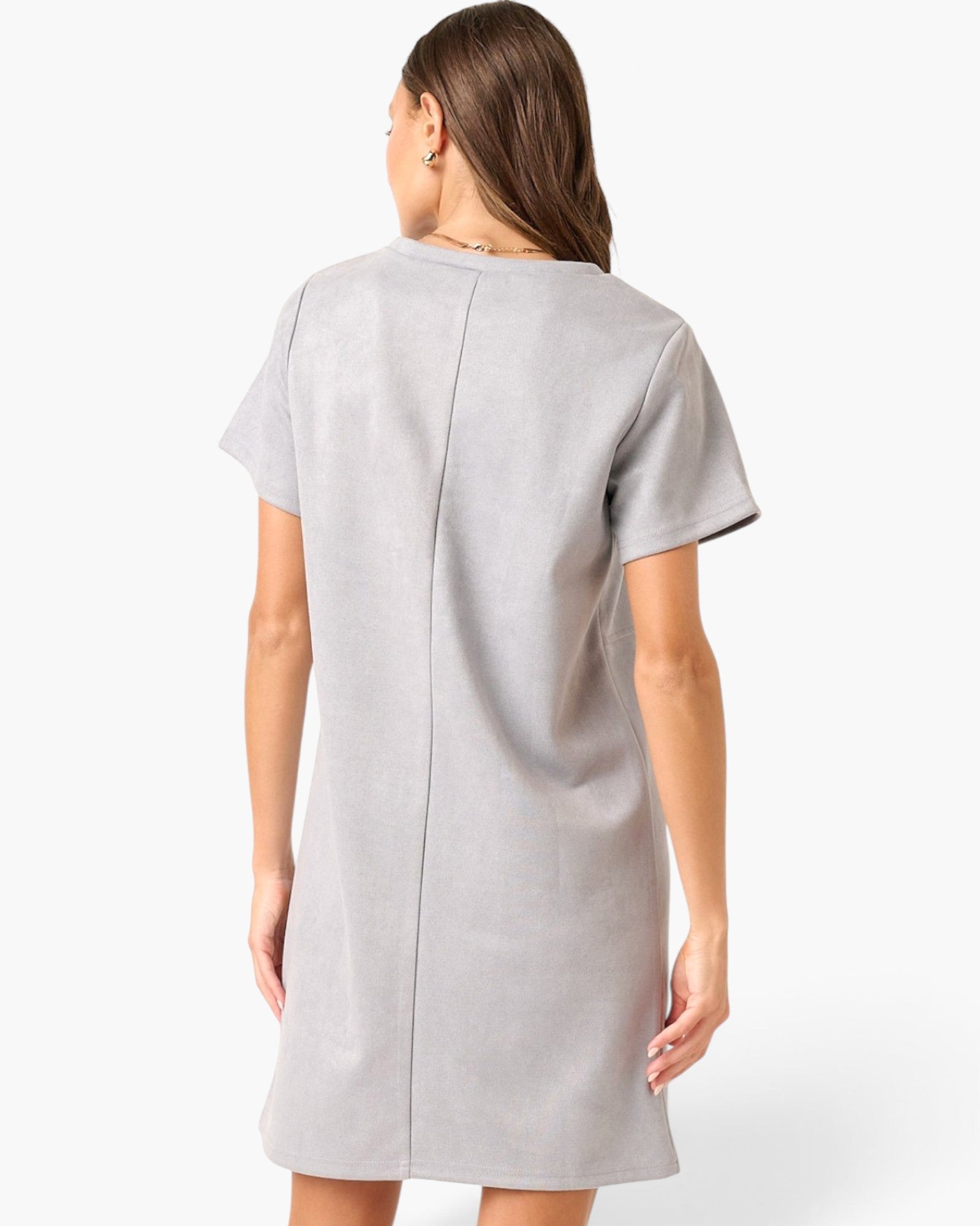A woman shown from the back wearing a light gray short-sleeve dress with a central seam, photographed against a clean white studio background.