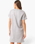 A woman shown from the back wearing a light gray short-sleeve dress with a central seam, photographed against a clean white studio background.