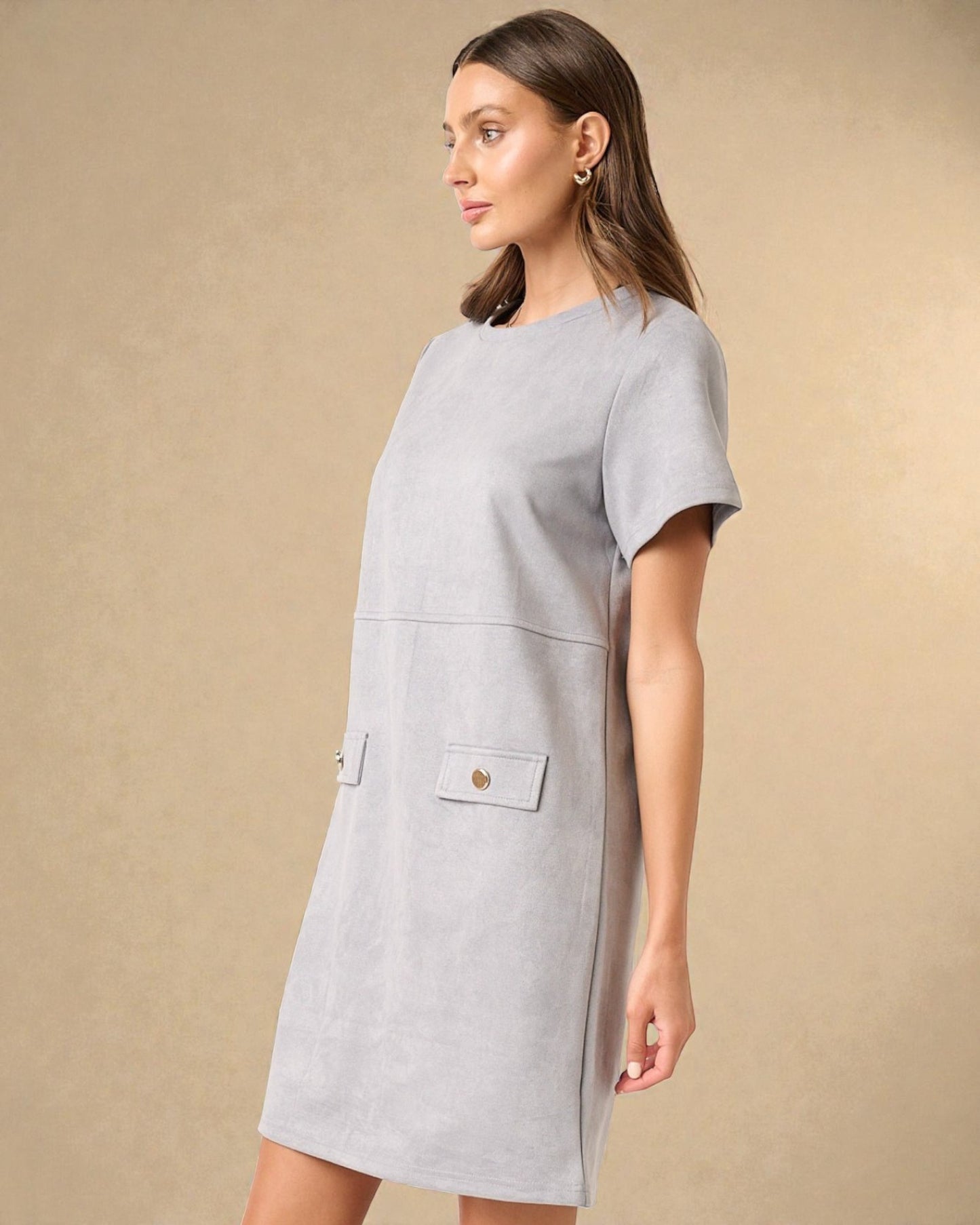 Woman wearing a light gray dress with a plain background