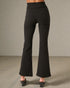Black flared pants worn by a person on a neutral background
