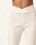 White leggings worn by a person on a pastel patterned background