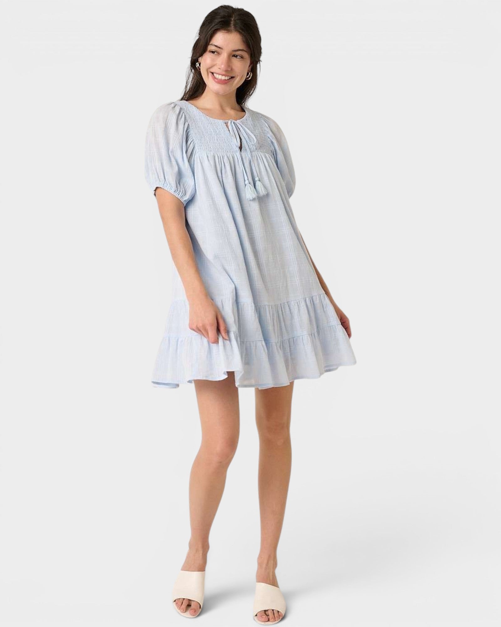 Woman wearing a light blue dress on a white background