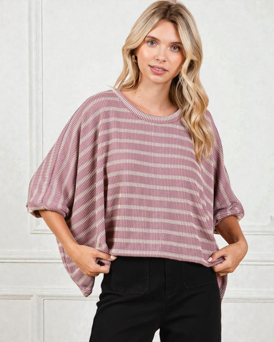 Woman wearing a striped pink and white top against a white background