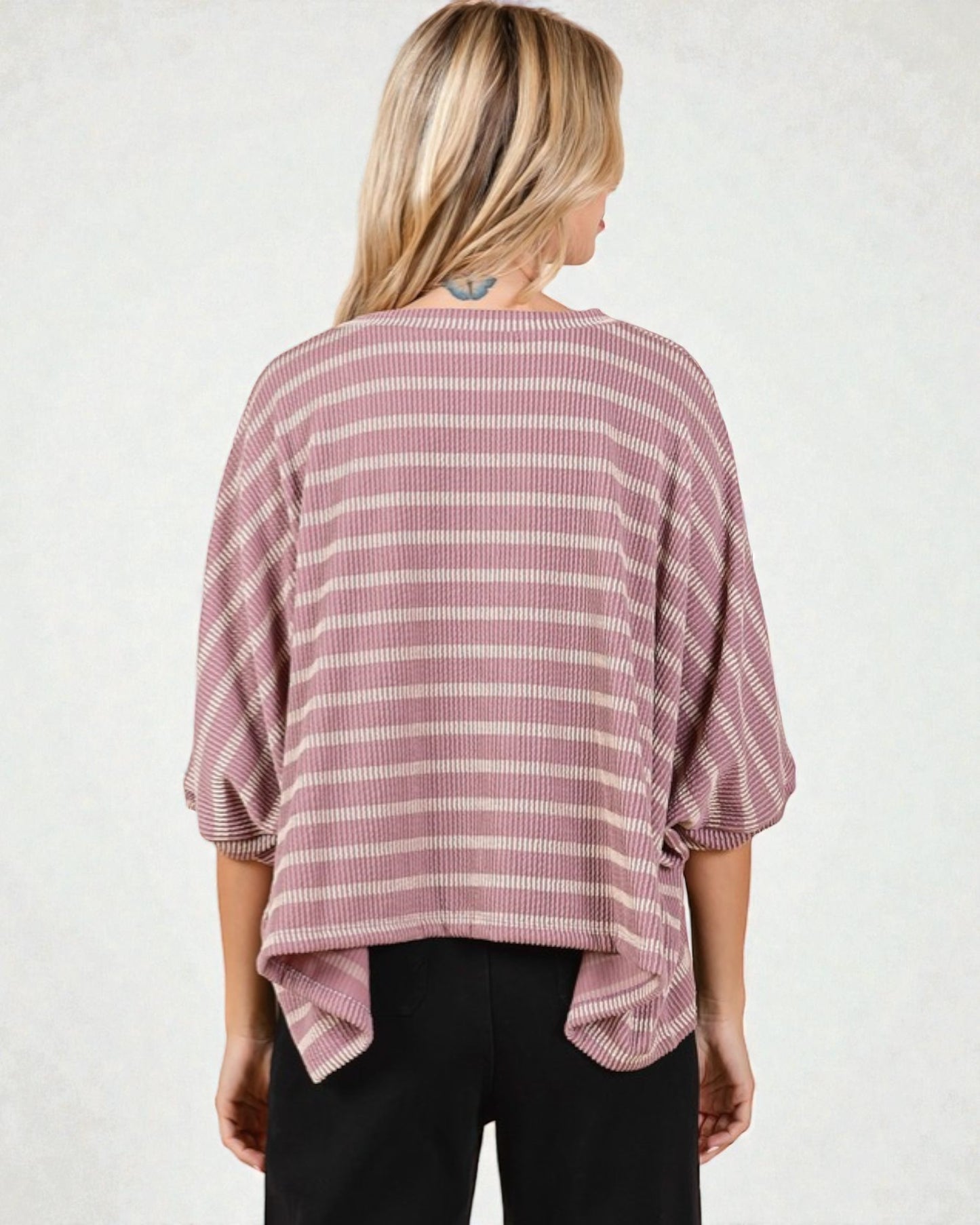 Woman wearing a pink and white striped shirt against a plain background