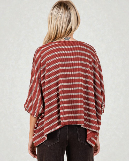 Person wearing a red and white striped sweater against a plain background