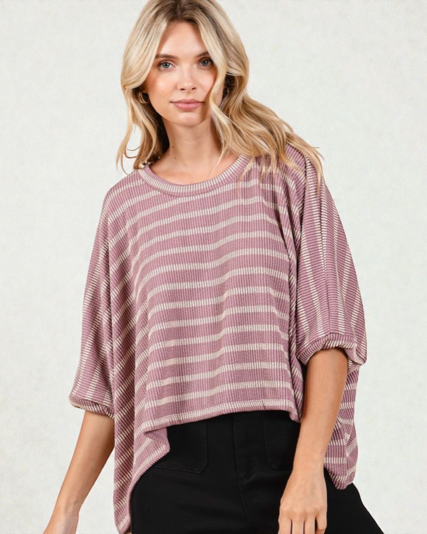 Woman wearing a striped pink and white top against a plain background