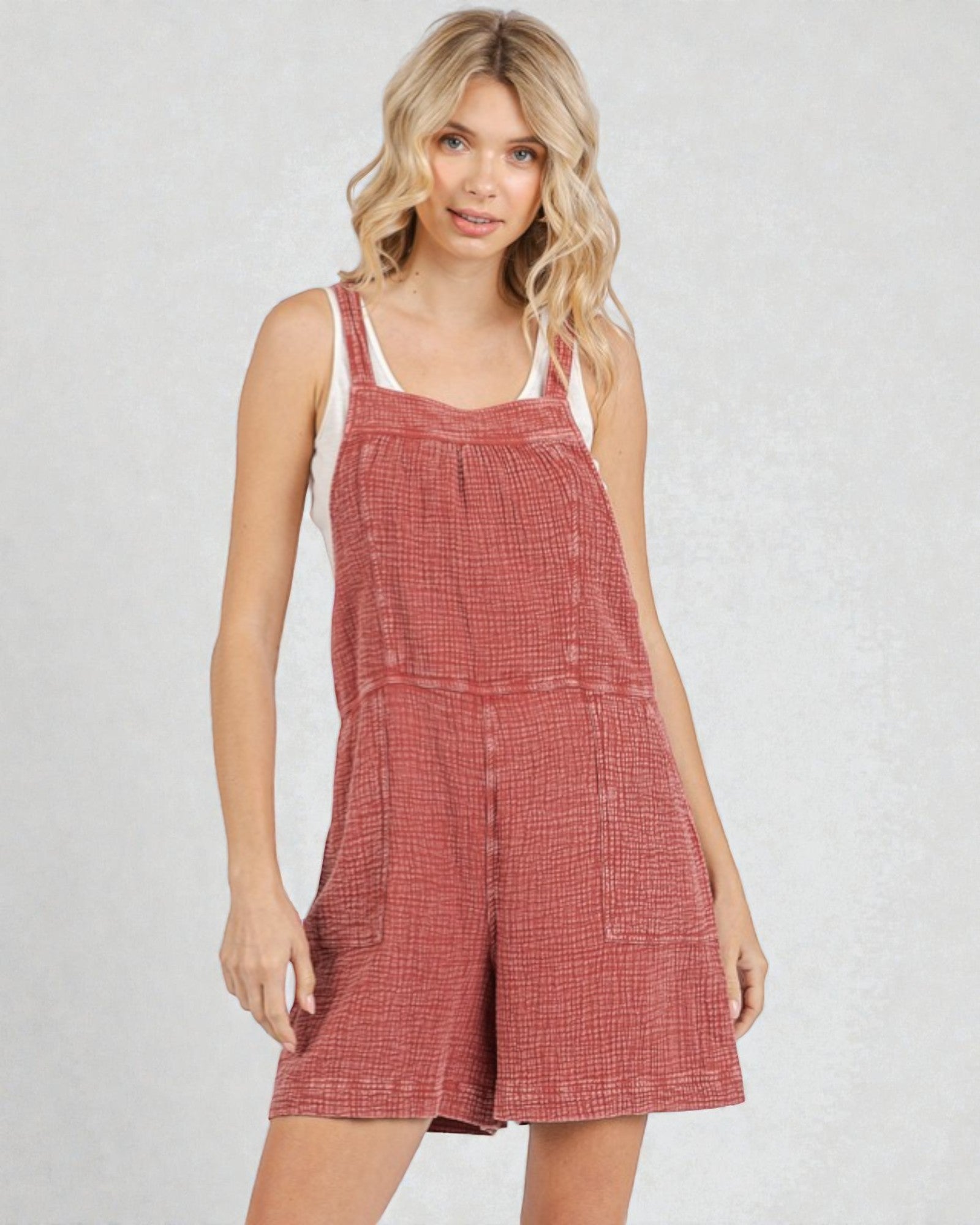 Woman wearing a red checkered dress against a plain background