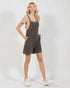 Woman wearing a plaid overall dress on a white background