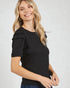 Woman wearing a black textured top with ruffled sleeves on a white background