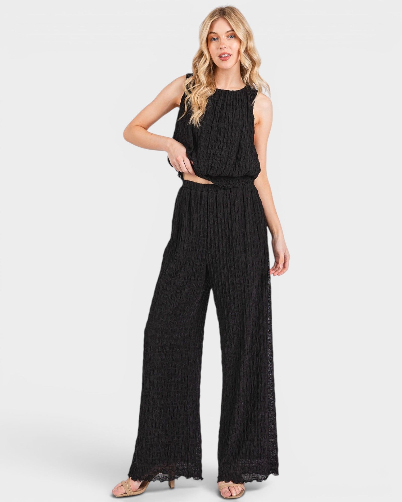 Woman wearing a black jumpsuit on a white background