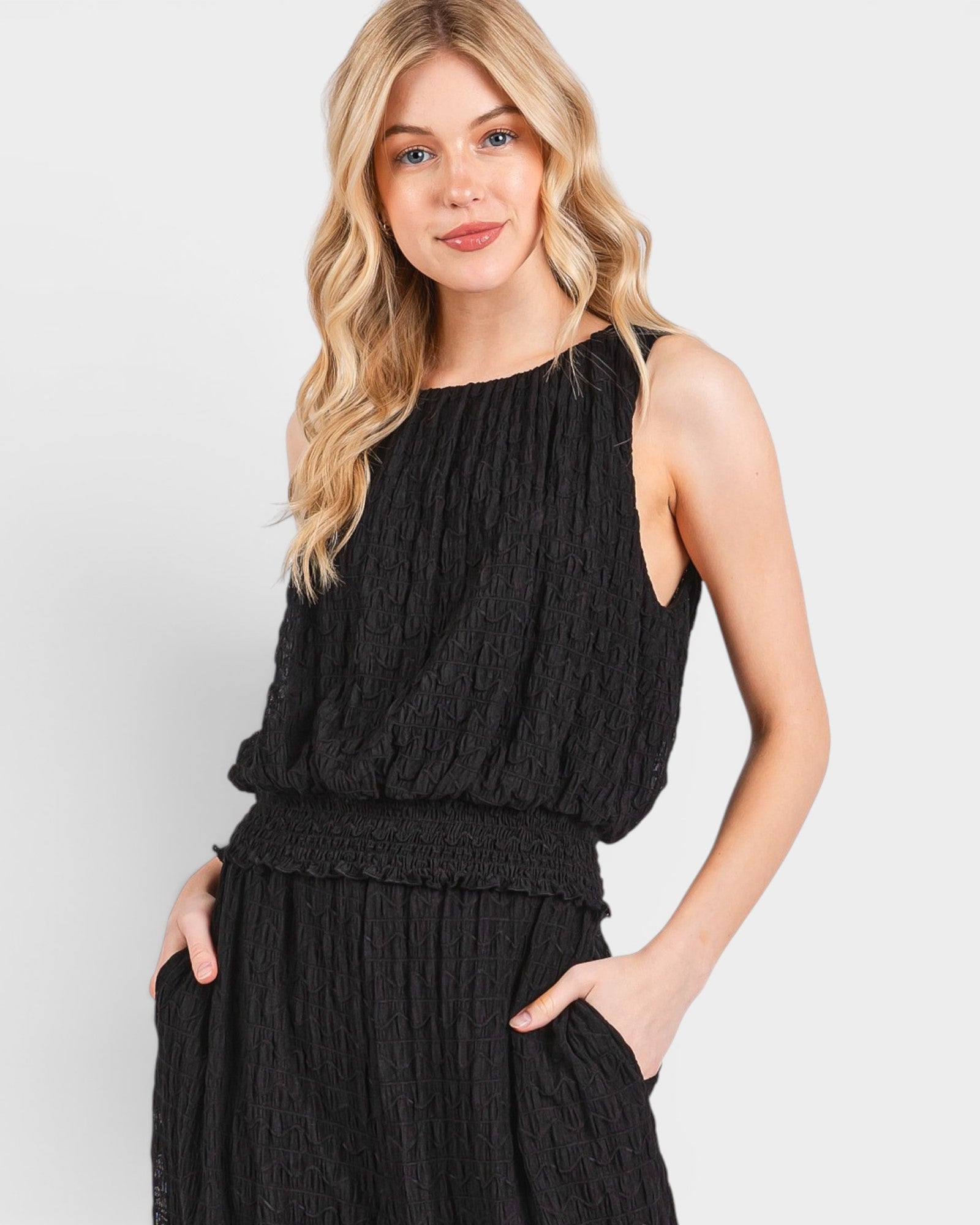 Woman wearing a black sleeveless top and skirt set on a white background