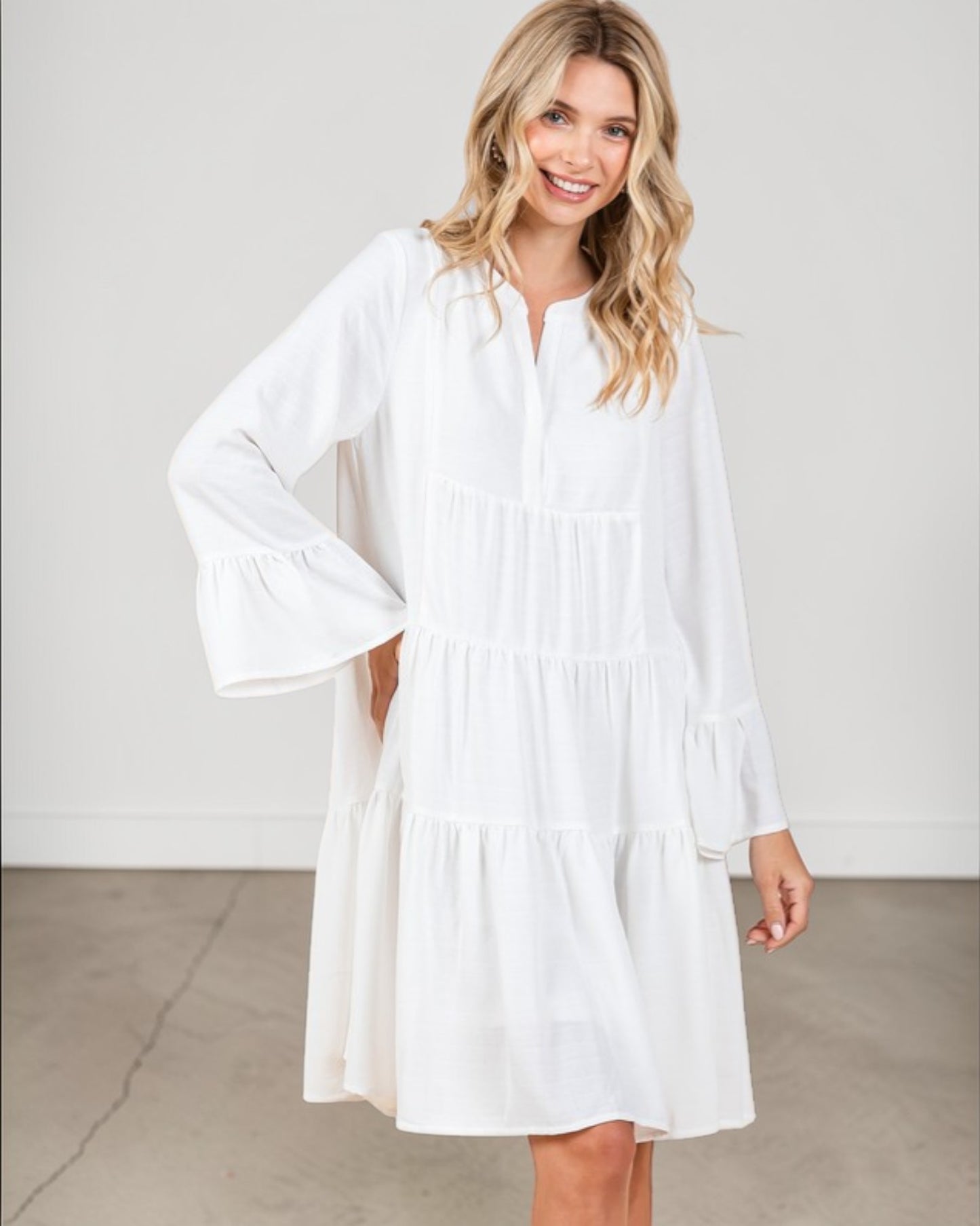 Woman wearing a white dress against a plain background
