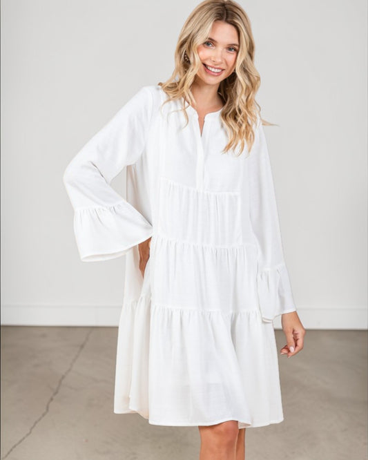 Woman wearing a white dress against a plain background